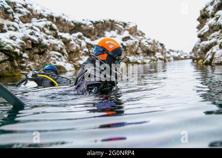 Silfra, Island-19. Feb 2020: Taucher bereiten sich auf das Eintauchen in das Wasser am Silfra Rift vor, dem Ort, an dem eurasische und die amerikanische tektonische Platte A liegen Stockfoto