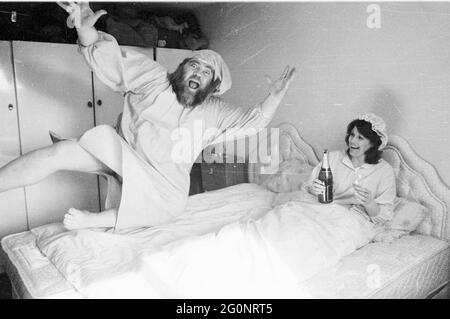 PUBLIZIST DES LEOPOLD PUB, PORTSMOUTH GEORGE EAST MIT SEINER FRAU DONNA NACH IHREM BETT WEN DURCH DIE KNEIPENDECKE, PIC MIKE WALKER, 1984 Stockfoto