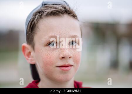 Nahaufnahme eines lächelnden Jungen im Teenageralter mit Sommersprossen im Gesicht und geringer Schärfentiefe Stockfoto