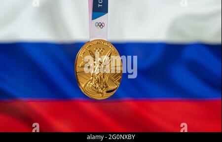 25. April 2021 Tokio, Japan. Goldmedaille der XXXII. Olympischen Sommerspiele 2020 in Tokio auf dem Hintergrund der russischen Flagge. Stockfoto