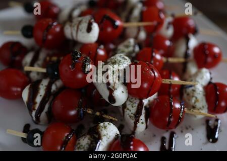 Vorspeise mit Tomaten, Käse und Oliven auf Holzspießen. Stockfoto