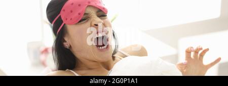 Frau schreit im Liegen auf dem Bett Stockfoto