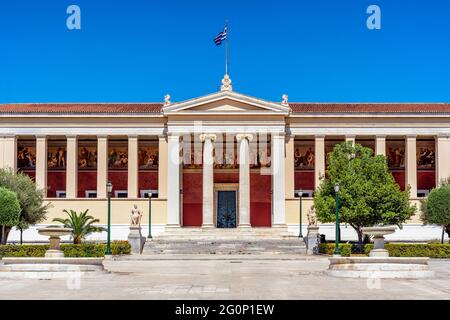 Athen, Attika, Griechenland. Das neoklassizistische Gebäude der Nationalen und Kapodistrianischen Universität von Athen. Blick auf die Fassade an einem sonnigen Tag Stockfoto