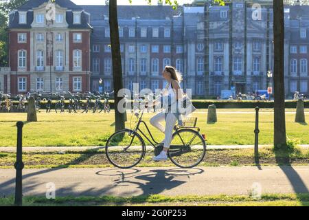 Münster, Deutschland. Juni 2021. Ein Radfahrer fährt an einem heißen und sonnigen Tag mit Temperaturen um die 28 Grad in der Universitätsstadt Münster am Schloss Münster vorbei. Die Covid-Zahlen sind in Deutschland stetig gesunken, was zu einer weiteren Lockerung der Beschränkungen führte. Münster zählt konsequent zu den Städten mit der niedrigsten Inzidenz in NRW. Kredit: Imageplotter/Alamy Live Nachrichten Stockfoto