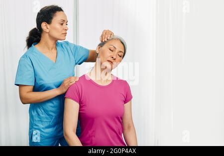 Manualtherapeut massiert den Hals reifer Frauen in einem Rehabilitationszentrum. Trainingsbehandlung für den menschlichen Hals Stockfoto