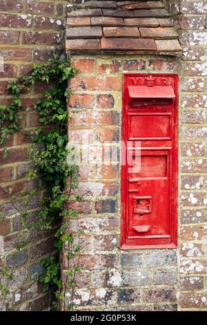 Alte veraltete typisch rote englische Briefkasten an der Wand von Ein Haus Stockfoto