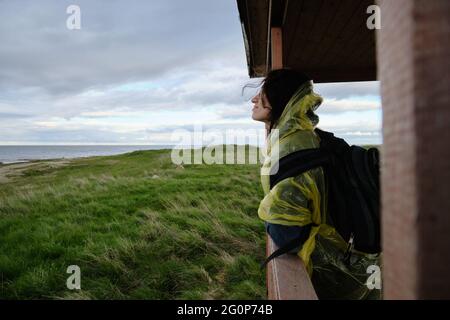 Das Mädchen schaut durch das Fenster auf die Natur. Reisen Sie allein außerhalb der Stadt. Stockfoto