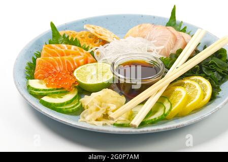 Sashimi-Set, japanische Küche. Sushi-Restoran-Menü. Japanische Meeresfrüchte. Sashimi-Set auf Teller mit Gurke und Salat Stockfoto