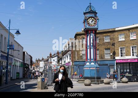 Frau in Gesichtsmaske Spaziergang am sheerness Uhrenturm auf der High Street, Stadtzentrum, Insel Sheppey, Kent, England, Großbritannien, Europa Stockfoto