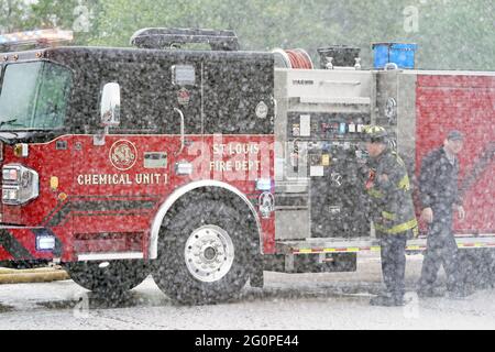 Die Feuerwehrleute von St. Louis überwachen einen Schaumsprühnebel aus einem neuen LKW zur chemischen Brandbekämpfung, der am Mittwoch, den 2. Juni 2021, der Abteilung von Ameren Missouri, einem Elektrizitätsunternehmen, in St. Louis gespendet wurde. Der eine Million Dollar schwere, einzigartige Feuerwehrwagen benötigte neun Monate für die Konstruktion und weitere neun Monate für den Bau. St. Louis hat jedes Jahr zwei bis drei erhebliche elektrische Erdbrände, die stundenlang brennen und Ausfälle verursachen können. Der neue Lkw bringt diese Brände in wenigen Minuten durch die Kühlung aller Komponenten mit einer Brandunterdrückungsanlage, die Kohlendioxid verwendet, um unterirdische Ele zu löschen Stockfoto