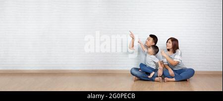 Asiatische Familie zeigt mit dem Finger auf etwas leeres Copyspace Stockfoto