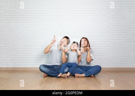 Asiatische Familie zeigt mit dem Finger nach oben Stockfoto