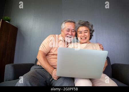 Asiatisches Seniorenpaar im Videoanruf-Chat auf einem Laptop-Computer, intelligente Technologie für das Alter und Online-Aktivismus in Verbindung bleiben Konzept Stockfoto