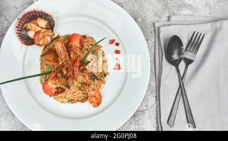 Peruanische Küche: Arroz chaufa mit Meeresfrüchten, gebratenem Reis, Garnelen, Jakobsmuscheln, Tintenfisch und Tintenfisch. Selektiver Fokus Stockfoto