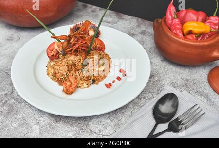 Peruanische Küche: Arroz chaufa mit Meeresfrüchten, gebratenem Reis, Garnelen, Jakobsmuscheln, Tintenfisch und Tintenfisch. Selektiver Fokus Stockfoto