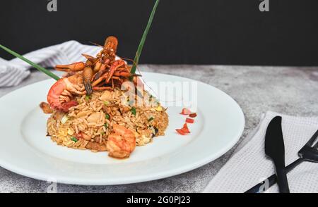 Peruanische Küche: Arroz chaufa mit Meeresfrüchten, gebratenem Reis, Garnelen, Jakobsmuscheln, Tintenfisch und Tintenfisch. Selektiver Fokus Stockfoto