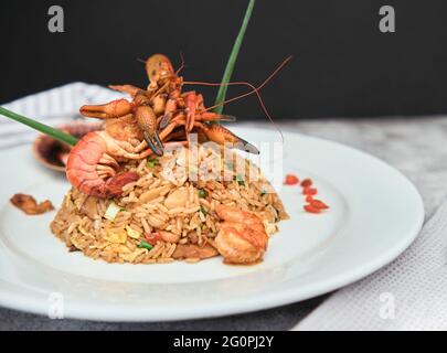 Peruanische Küche: Arroz chaufa mit Meeresfrüchten, gebratenem Reis, Garnelen, Jakobsmuscheln, Tintenfisch und Tintenfisch. Selektiver Fokus Stockfoto