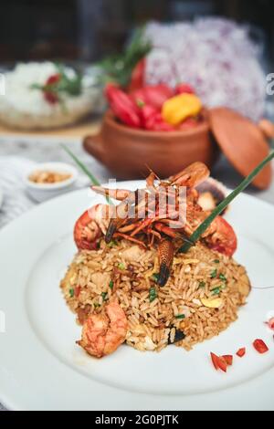 Peruanische Küche: Arroz chaufa mit Meeresfrüchten, gebratenem Reis, Garnelen, Jakobsmuscheln, Tintenfisch und Tintenfisch. Selektiver Fokus Stockfoto