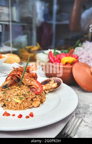 Peruanische Küche: Arroz chaufa mit Meeresfrüchten, gebratenem Reis, Garnelen, Jakobsmuscheln, Tintenfisch und Tintenfisch. Selektiver Fokus Stockfoto