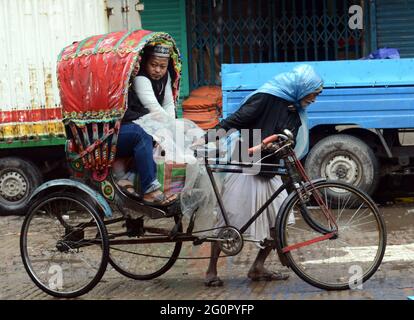 Bunte Rikschas durchstreifen die Straßen von Dhaka, Bangladesch. Stockfoto