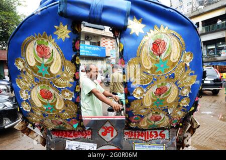 Bunte Rikschas durchstreifen die Straßen von Dhaka, Bangladesch. Stockfoto