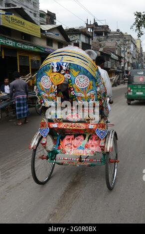 Bunte Rikschas durchstreifen die Straßen von Dhaka, Bangladesch. Stockfoto