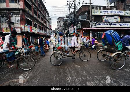 Bunte Rikschas durchstreifen die Straßen von Dhaka, Bangladesch. Stockfoto