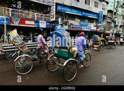 Bunte Rikschas durchstreifen die Straßen von Dhaka, Bangladesch. Stockfoto