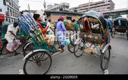 Bunte Rikschas durchstreifen die Straßen von Dhaka, Bangladesch. Stockfoto