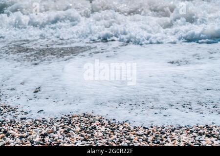 Abstrakte Natur Sommer oder Frühling Meer Meer Hintergrund. Kleine Wellen auf der goldenen, warmen Wasseroberfläche verwischen sich in Bewegung mit Bokeh-Lichtern vom Sonnenuntergang. Urlaub Stockfoto