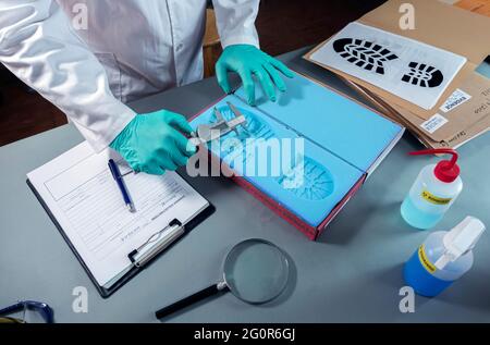 Forensischer Wissenschaftler untersucht Schuhdruck Schimmel Beweise im Kriminallabor, konzeptuelles Bild Stockfoto
