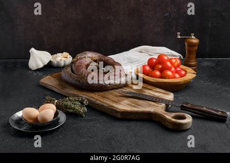 Blutwurst auf Holzschneidebrett gerollt Stockfoto