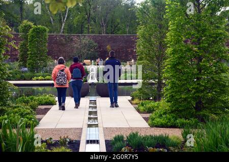 Menschen, die am Teich und den Wassereinrichtungen im viktorianischen Weston Walled Paradise Garden im RHS Garden Bridgewater, Worsley, Manchester, Großbritannien, spazieren gehen. Stockfoto