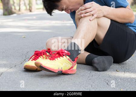 Knieschmerzen, die Schmerzen um die Kniescheibe verursachen, Laufverletzungen des Laufkonzepts Stockfoto