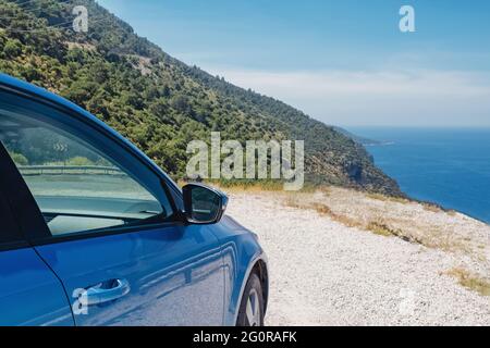 Blaues Auto hielt am Straßenrand in der Nähe des Meeres an sonnigen Tag Stockfoto