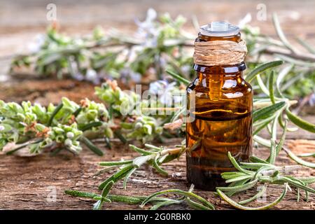 Ätherisches Öl aus Rosmarin auf rustikalem Tisch Stockfoto