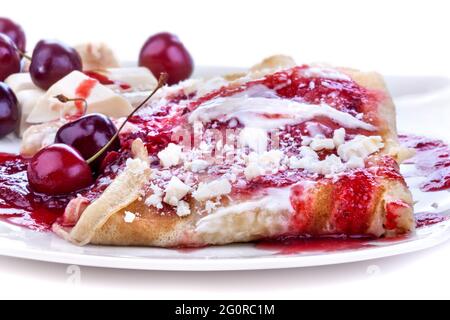 Pfannkuchen mit Marmelade und Kirschen mit weißer Schokolade gekrönt Stockfoto