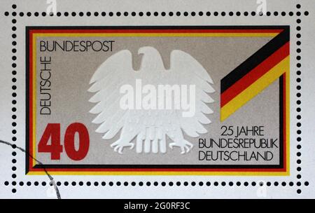 Eine in Deutschland gedruckte Marke zeigt Bundesadler und Flagge, 25 Jahre Bundesrepublik Deutschland, um 1974 Stockfoto