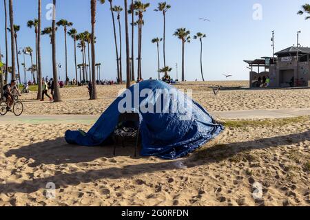 LOS ANGELES, USA - 23. Mai 2021: Ein Zelt mit Plane darüber liegt am Strand in der Nähe der Venice Beach Promenade. Obdachlose haben Zelte Stockfoto