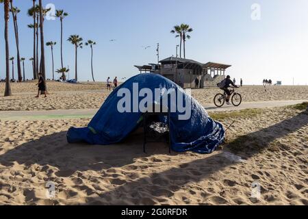 LOS ANGELES, USA - 23. Mai 2021: Ein Zelt mit Plane darüber liegt am Strand in der Nähe der Venice Beach Promenade. Obdachlose haben Zelte Stockfoto