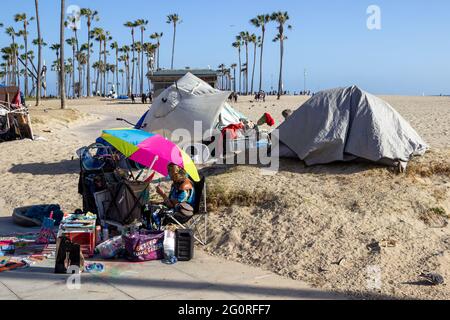 LOS ANGELES, USA - 23. Mai 2021: Obdachlose mit Zelten hinter Verkäufern auf der Venice Beach Promenade Stockfoto