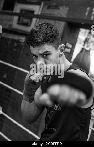 Junger Sportler bereitet sich auf Boxwettbewerbe, Training Verteidigung und Angriffe im Boxclub. Stockfoto