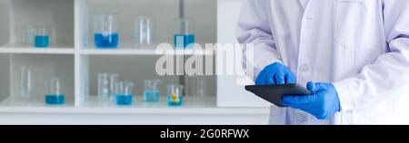 Tablet-Computer in der Hand der Forscher. Coronavirus Disease 2019-Testverfahren in einem Labor. Nahaufnahme Stockfoto