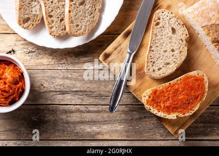 Toastbrot in Scheiben mit Sobrasada auf rustikalem Holztisch Stockfoto