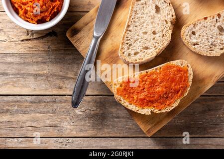 Toastbrot in Scheiben mit Sobrasada auf rustikalem Holztisch Stockfoto