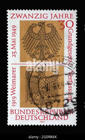 In Deutschland gedruckte Briefmarke zeigt heraldische Adler der Bundes- und Weimarer Republiken, 20 Jahre Deutsches Grundgesetz und 50 Jahre Proclamat Stockfoto