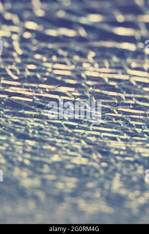 Texturrisse auf dem zerbrochenen Glas sind blau, Hintergrund Stockfoto