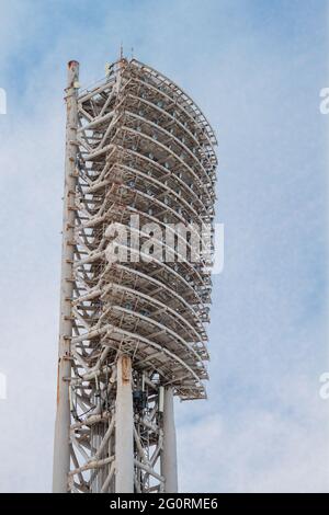 Ein Turm mit Flutlichtern, der ein Sportstadion beleuchtet, tagsüber gegen einen bewölkten Himmel. Nahaufnahme Stockfoto