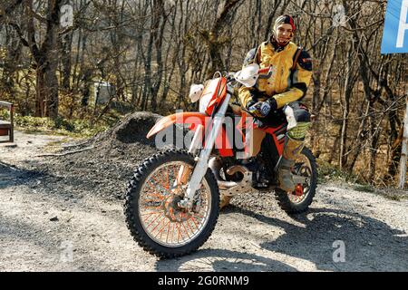 KRASNODAR, RUSSLAND - OKTOBER 2020: Männlicher Fahrer sitzt auf dem Motorrad auf der Straße im Wald Stockfoto