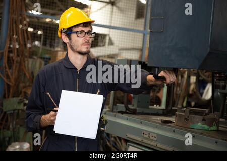 Werksingenieur mit gelbem Schutzhelm und Überprüfung der Maschine, jährliches Wartungskonzept Stockfoto